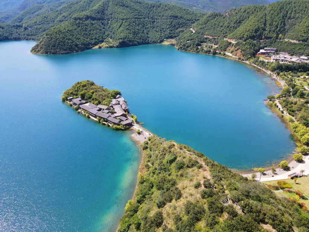 Aerial view of Lige Peninsula on Lugu Lake — Mosuo village on a promontory in crystal-clear water
