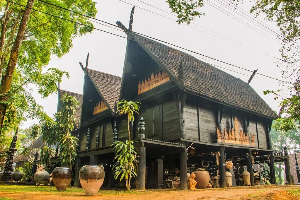 Traditional Dai stilted bamboo house with thatched roof in a tropical garden