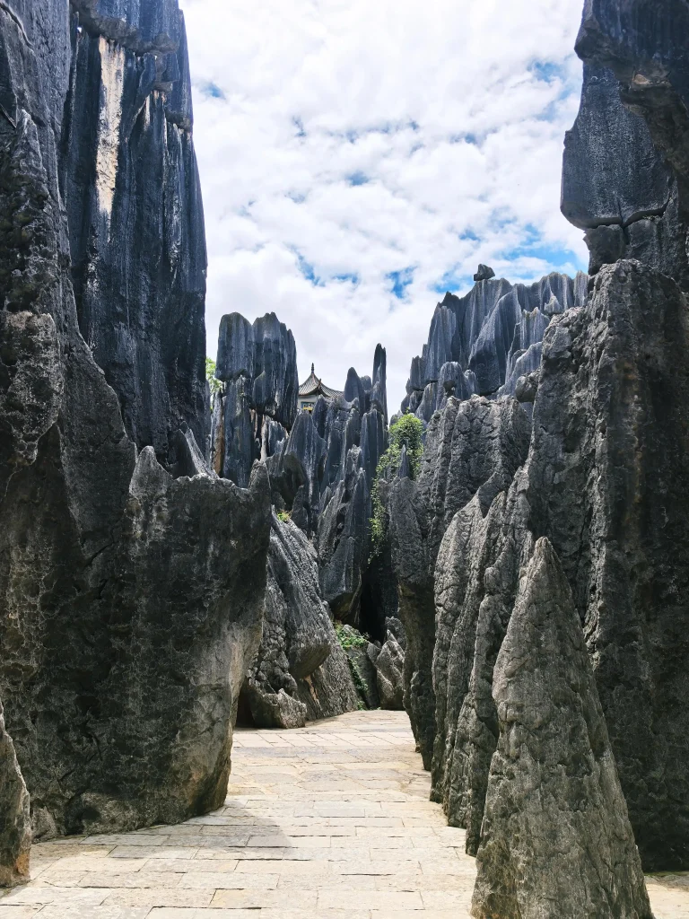 Visitors walking through narrow paths between towering limestone pillars in the Major Stone Forest